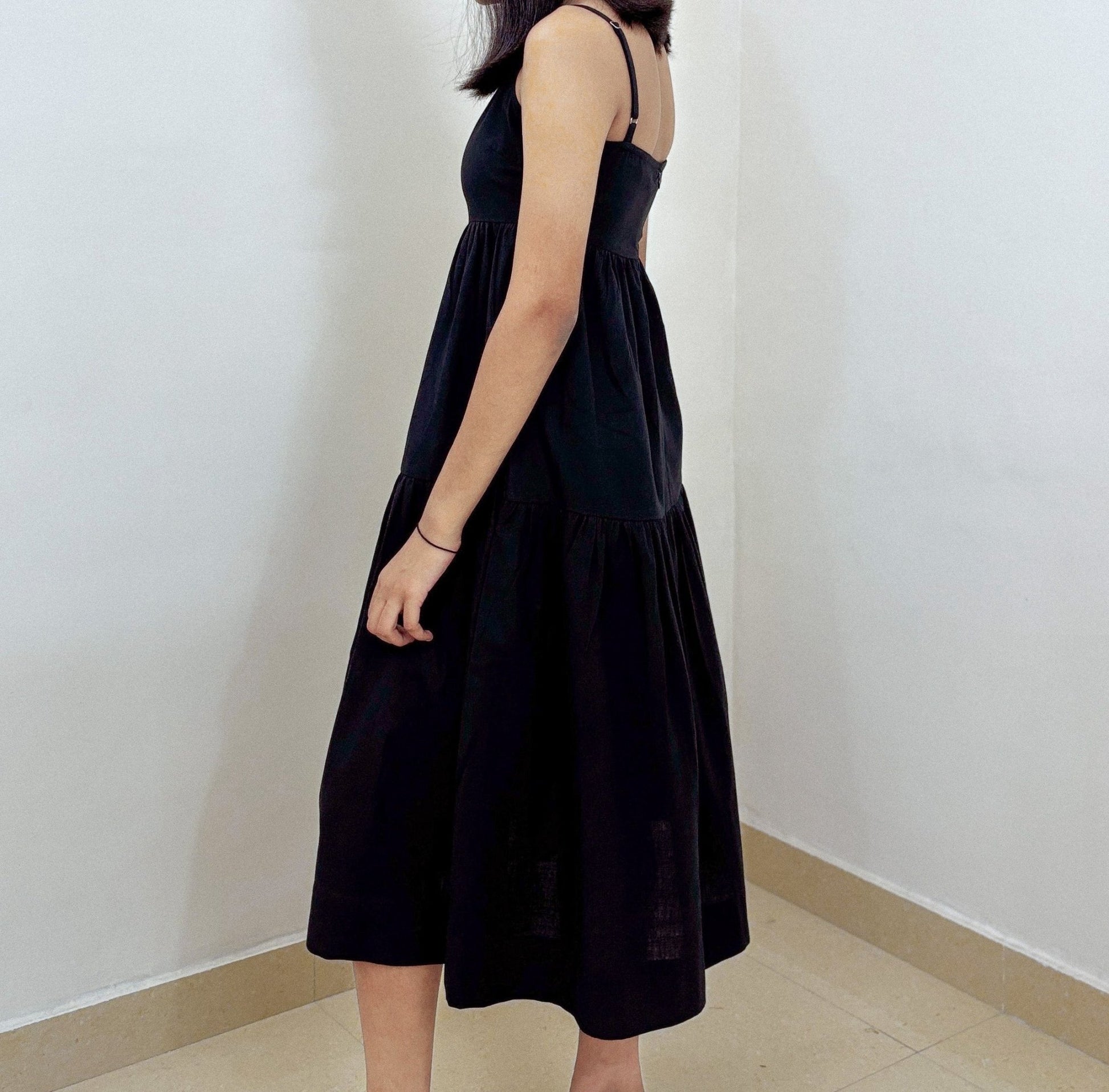 Side profile of Aria Midi Dress on model against plain studio backdrop