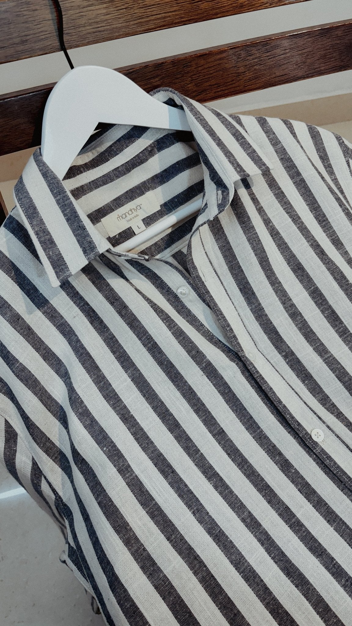 Close-up of Tarang men’s striped cotton shirt fabric and buttons in studio lighting