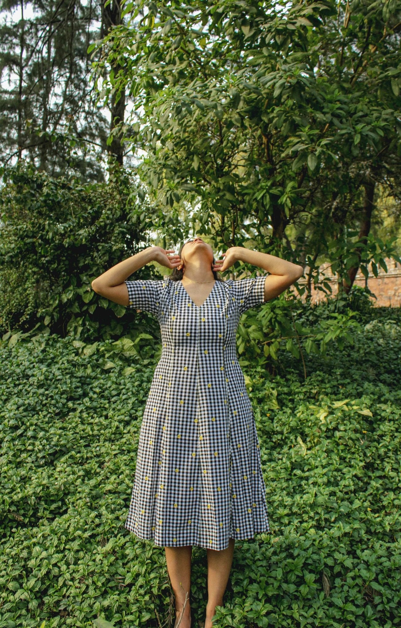 Model wearing Vanya Midi Dress in gingham pattern – front view