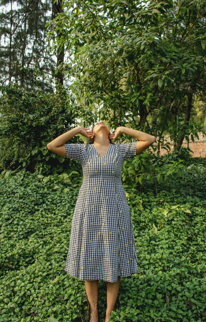 Model wearing Vanya Midi Dress in gingham pattern – front view